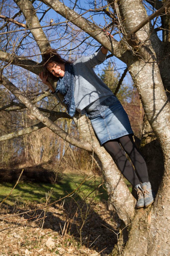 Frau steht auf Baum